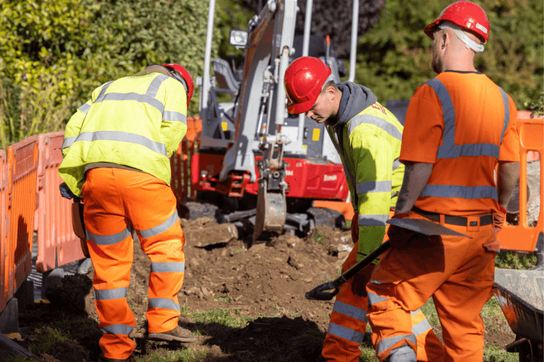 Three workers dig up a road as we continue to build our own, state of the art, broadband network across the South West