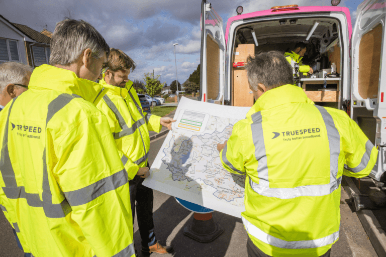 A number of the Truespeed team looking at a map of the South West. The map shows the areas we'll be connecting to full-fibre broadband in the next few months